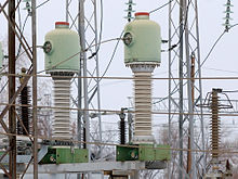 Minaret-like electrical devices with wires around them, thicker at the bottom